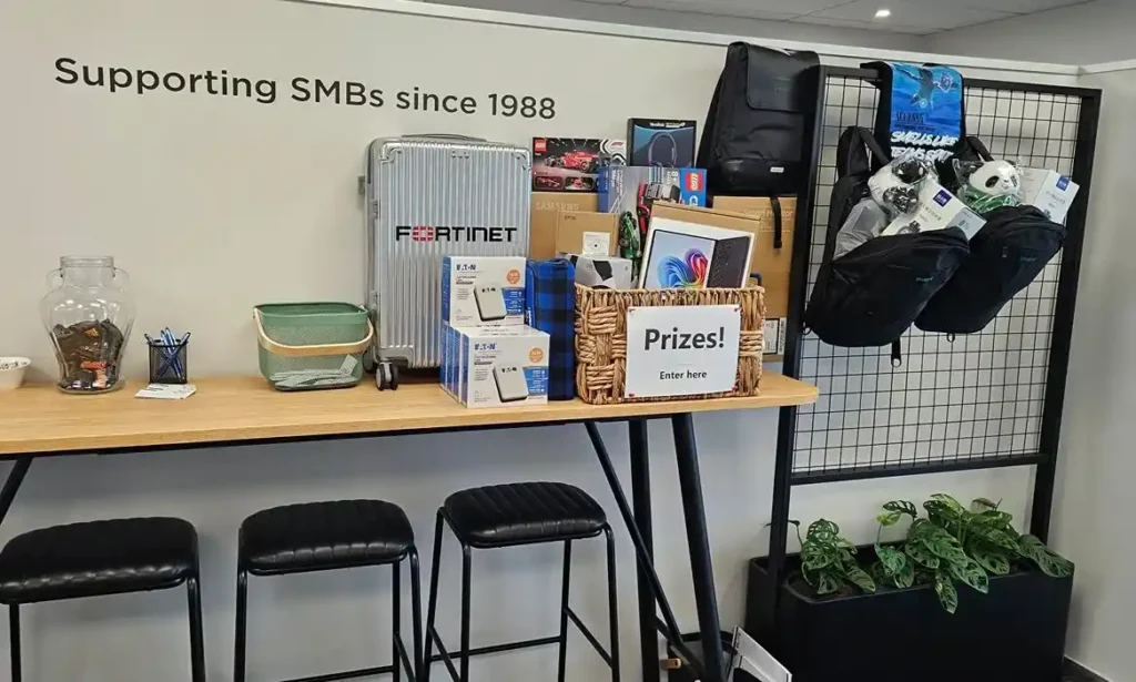 Prize table at Elite Open Day 2026 Hamilton featuring Microsoft Surface Laptop Samsung monitor Yealink headsets and more
