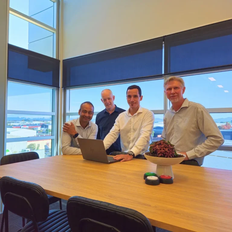 Elite Business Systems team members at standing desk with laptop